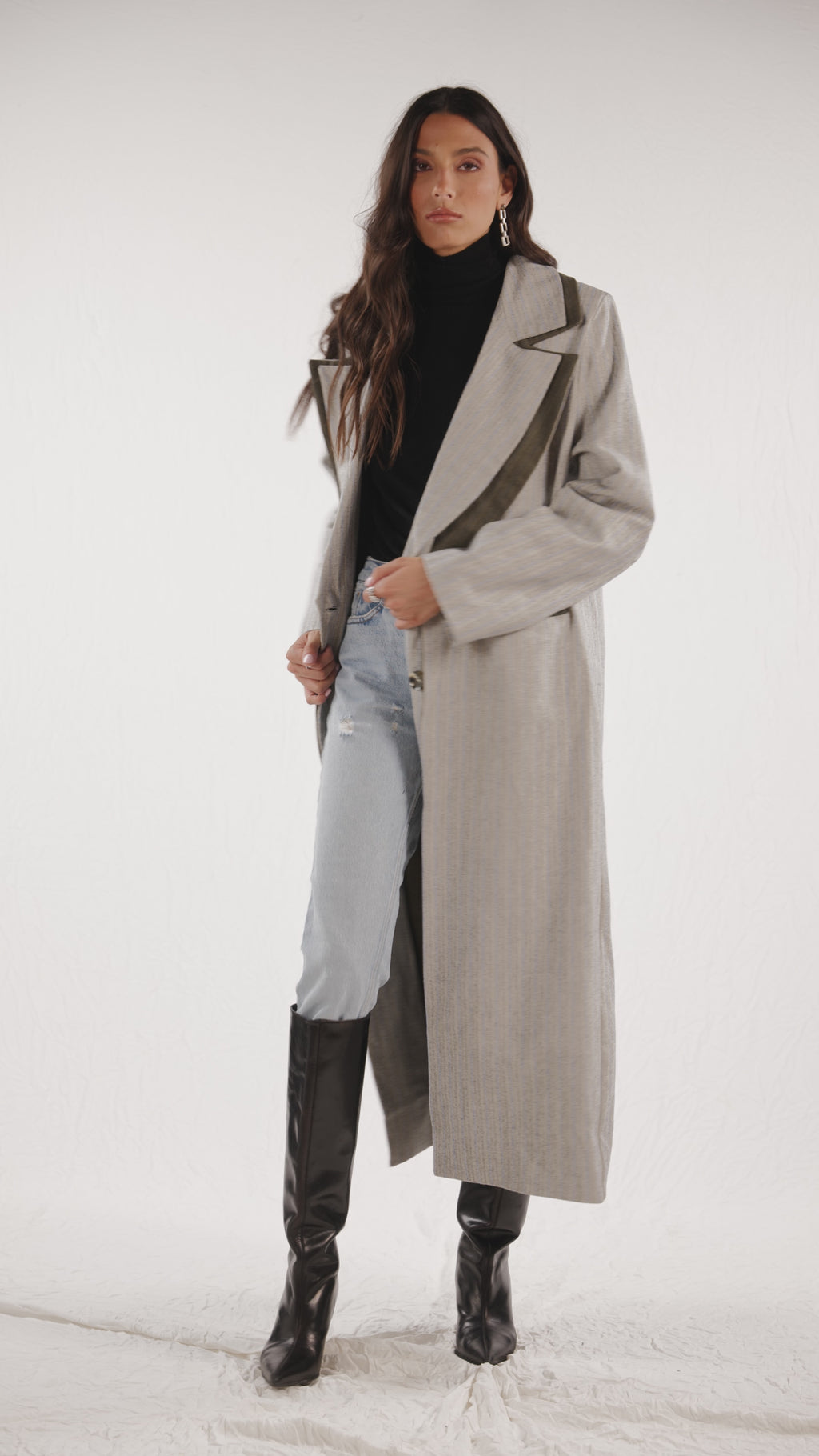 Long grey and dark green trench coat with open back adorned with tortoise shell buttons covered with a placket.