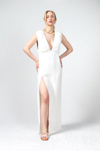 White linen maxi dress with gathered details on the bodice and a side slit