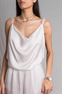 White satin jumpsuit with a cowl neckline thin straps and a risque low back