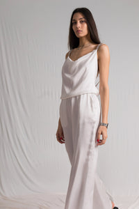 White satin jumpsuit with a cowl neckline thin straps and a risque low back