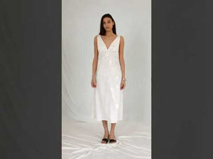 White sleeveless with deep V neckline a hidden back zipper and a relaxed silhouette in midi length dress