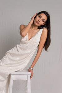 White sleeveless with deep V neckline a hidden back zipper and a relaxed silhouette in midi length dress