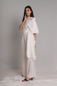 White cropped top with a relaxed cowl neckline and high-waist pants with a hidden zipper pockets and a hand-ruched waistband